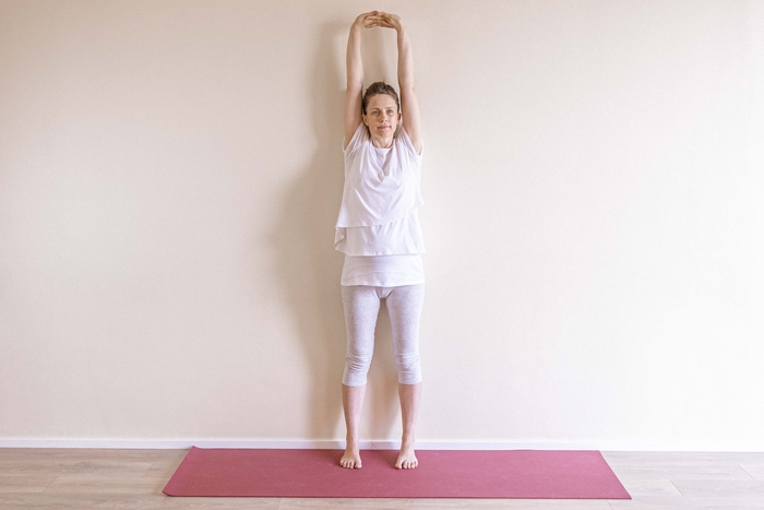 Tadasana - Mountain Pose A young pregnant woman stands in Mountain Pose to soothe nausea.