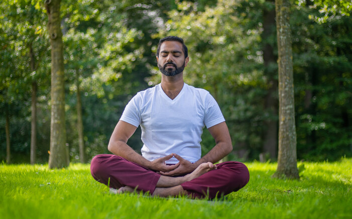 A man practices yoga meditation outside