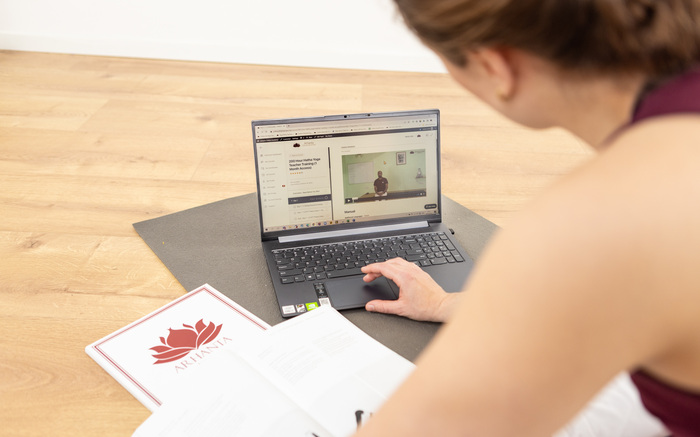 A woman learns how to do yoga at home