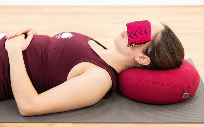 A woman practices yoga at home with props