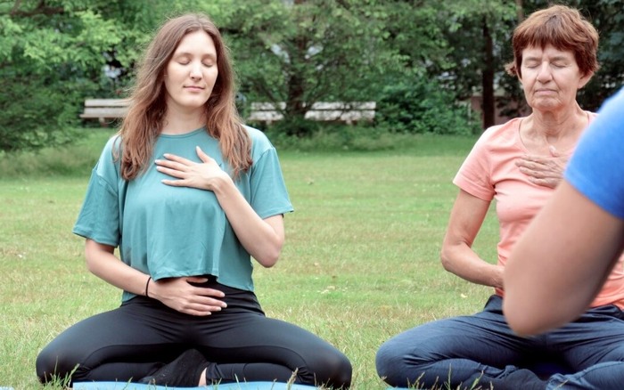 Group of yoga practitioners meditate outside to balance their doshas Group of yoga practitioners meditate outside to balance their doshas