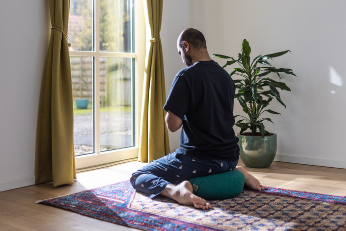 A yoga practitioner creates an at-home yoga space