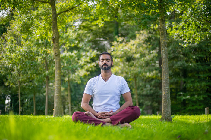 A yoga practitioner practices mindfulness meditation outside A yoga practitioner practices mindfulness meditation outside