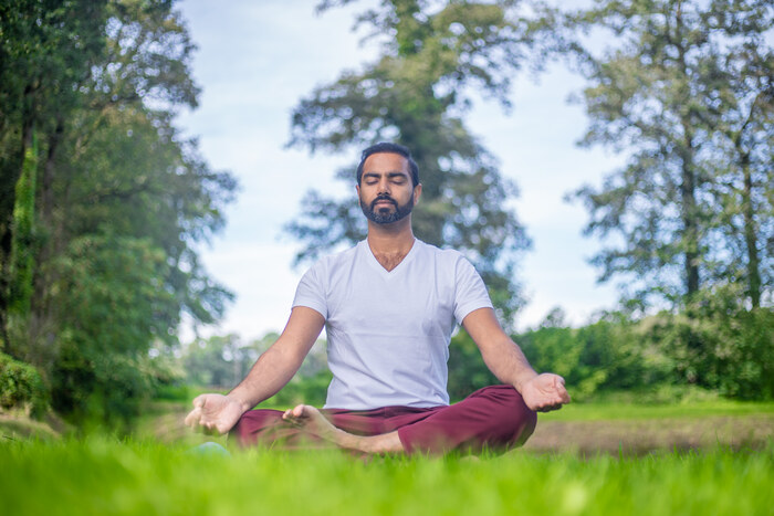 Yoga practitioner meditates outside