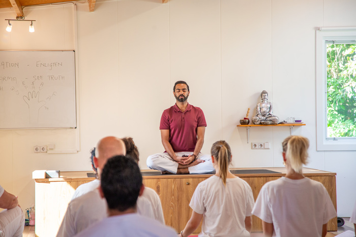 Yoga teacher and students meditate in silence