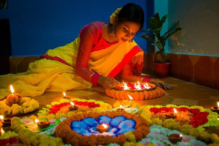 An Indian woman lights diyas during Diwali An Indian woman lights diyas during Diwali