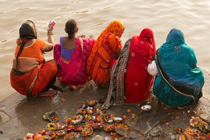 Five women in traditional Indian clothing pray beside the Ganga in Varanasi Five women in traditional Indian clothing pray beside the Ganga in Varanasi