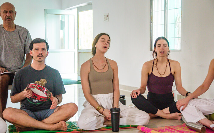 Students chant during a yoga teacher training in India Students chant during a yoga teacher training in India