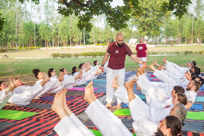 Yoga instructor correcting students’ posture