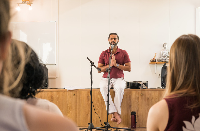 A yoga teacher ends a class with namaste A yoga teacher ends a class with namaste
