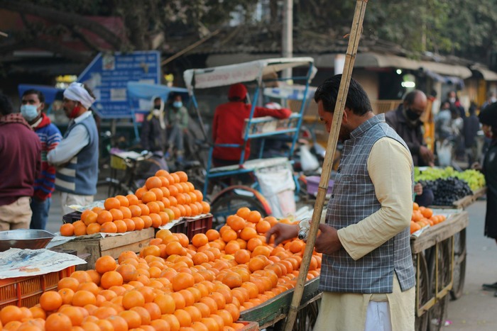 Man buys fruit at a market in Delhi, India Man buys fruit at a market in Delhi, India