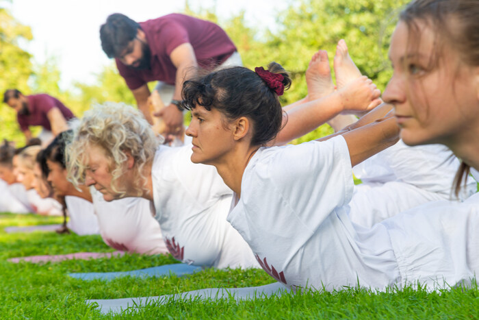 Yoga students practice Bow Pose in nature