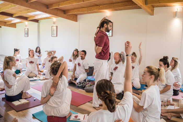 Yoga teacher giving tips to students in yin yoga class Yoga teacher giving tips to students in yin yoga class