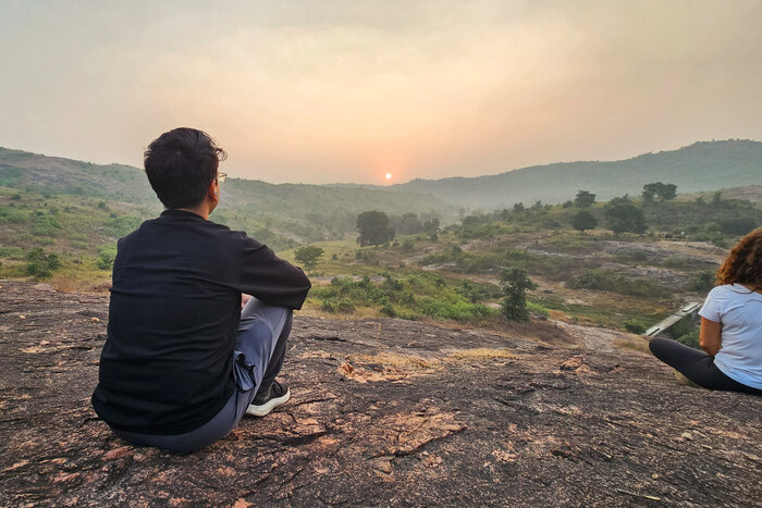 A man sits overlooking the countryside in India A man sits overlooking the countryside in India