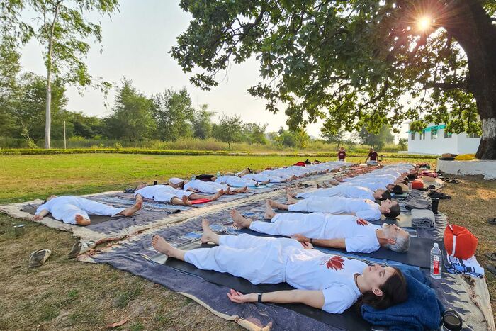Outdoor corpse pose relaxation Yoga students relaxing in corpse pose in an outdoor yoga class