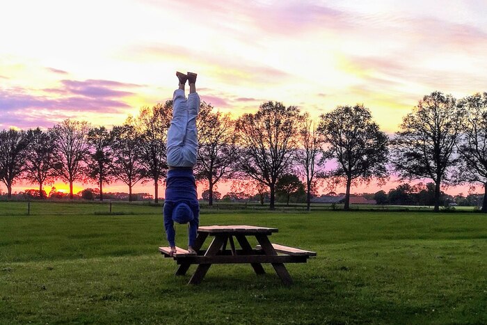 Man performing Handstand or Adho Mukha Vrksasana in an outdoor setup