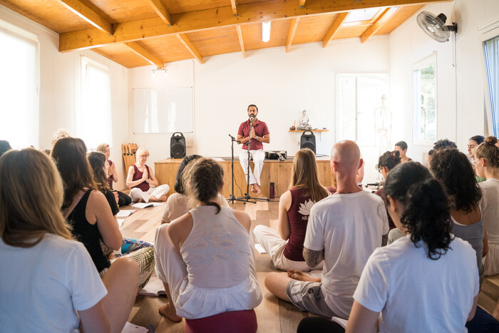 Yoga guru reciting mantras and yoga students following