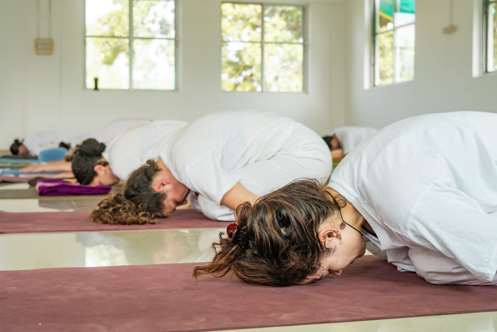 Child pose practice Class of yoga students learning child pose at yoga ashram