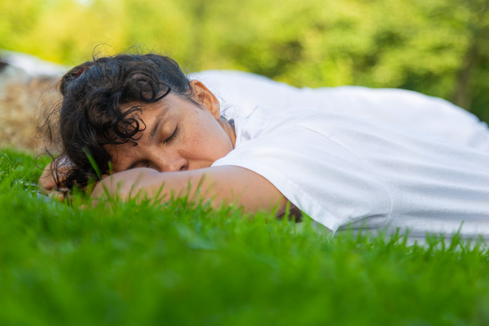 Simple Pratyahara Practice for Mental Rest and Digital Detox Yoga student resting peacefully on grass during a sensory reset practice