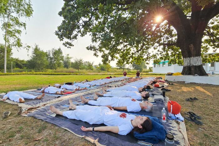 Yoga students practicing corpse pose during outdoor practice