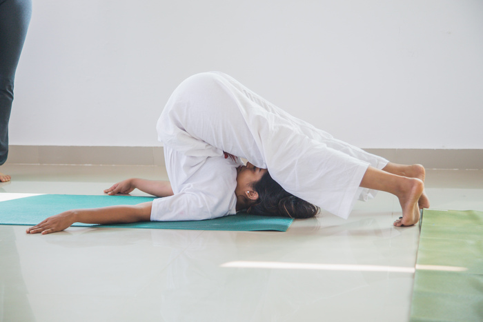 Student demonstrating challenging pose in yoga class at ashram 